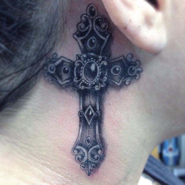 Black Ink Cross Tattoo On Right Behind The Ear By Pig Legion
