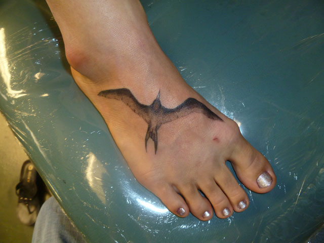 Black Ink Flying Iwa Bird Tattoo On Girl Right Foot By Tyler Bishop