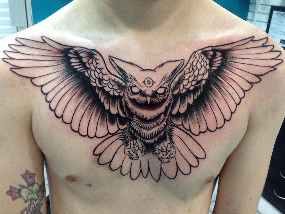 Black Ink Flying Owl Tattoo On Man Chest