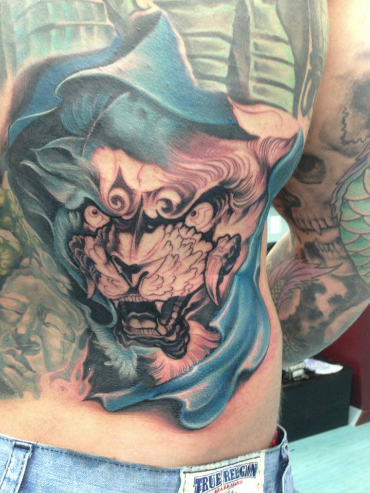 Black Ink Foo Dog Face Tattoo On Man Lower Back