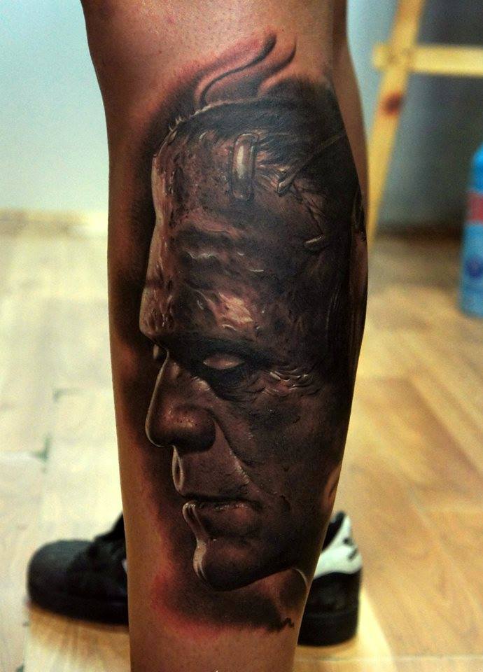 Black Ink Frankenstein Head Tattoo On Left Leg Calf