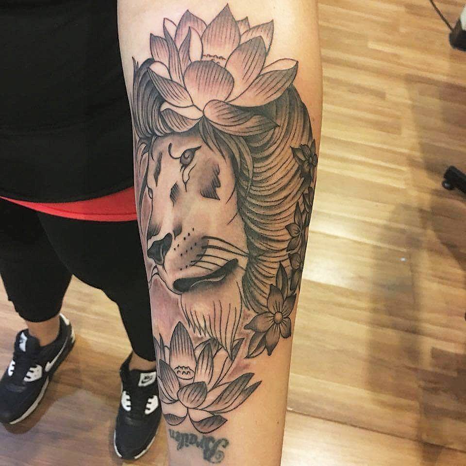 Black Ink Lion Head With Lotus Flowers Tattoo On Left Forearm