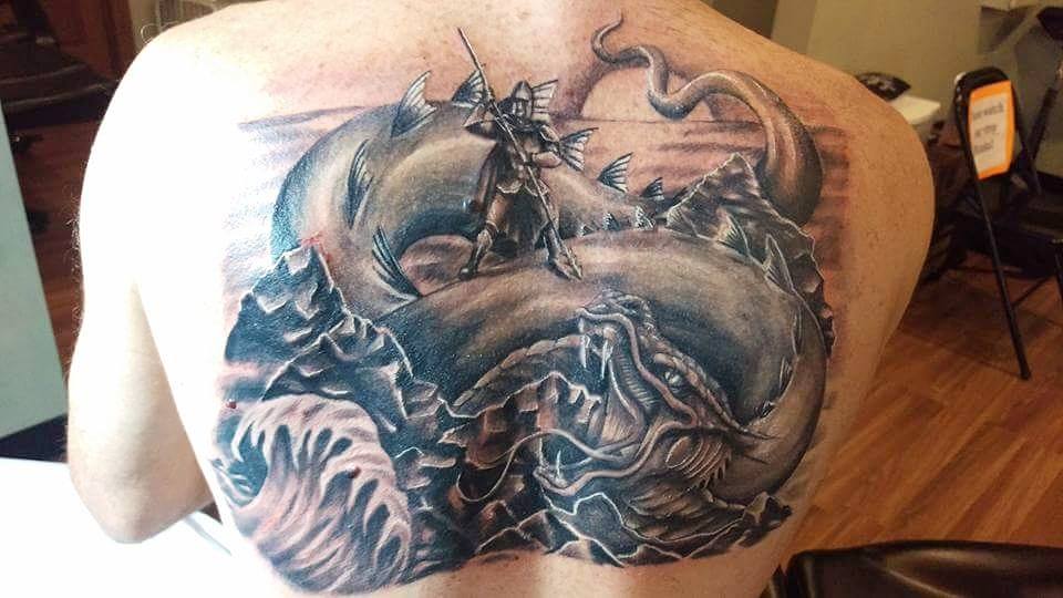 Black Ink Serpent Fight With Dragon Tattoo On Man Upper Back