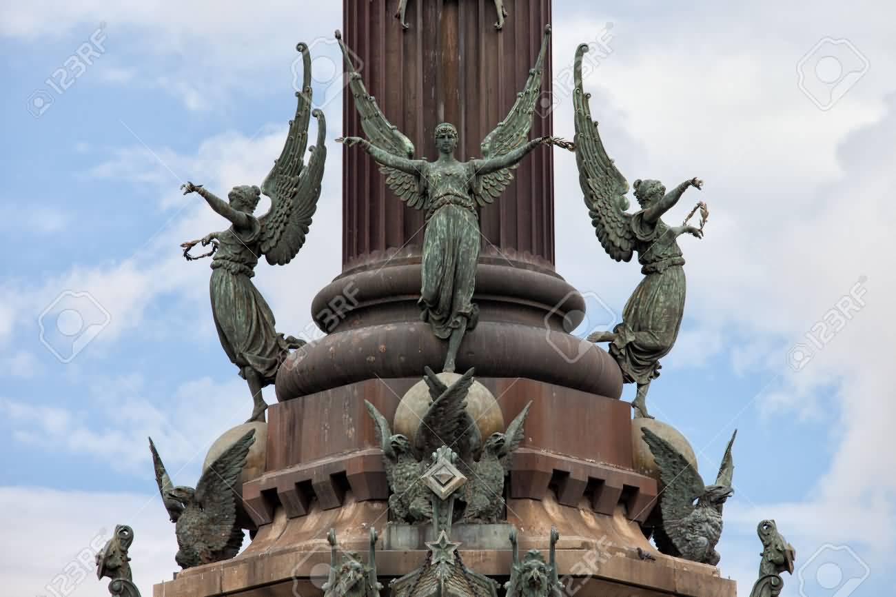 Closeup Of Phemes, Winged Persoification Of Fame And Griffins Statues On Pedestal Of Columbus Monument In Barcelona