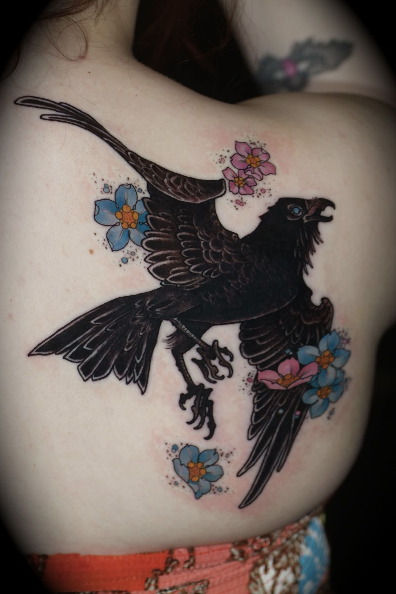 Flying Crow With Colorful Flowers Tattoo On Women Right Back Shoulder