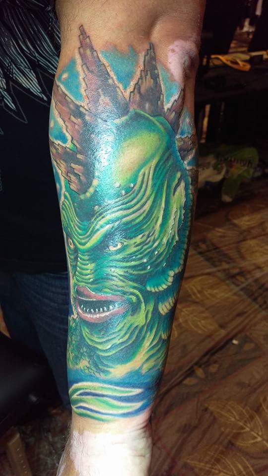 Green Ink Alien Head Tattoo On Left Arm By Laura Frego