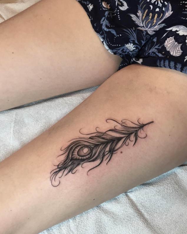 Grey Ink Peacock Feather Tattoo On Girl Thigh