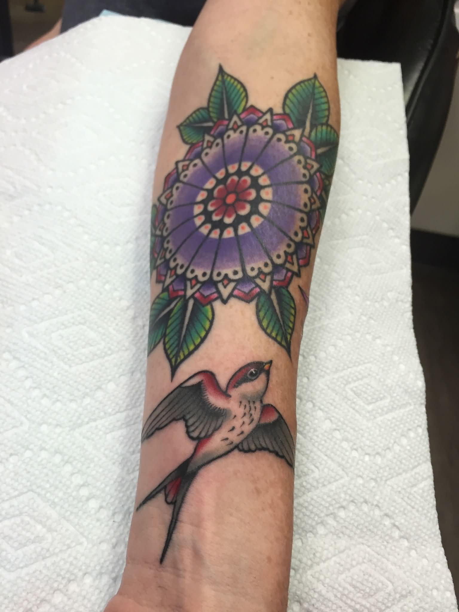 Traditional Colorful Flower With Flying Bird Tattoo On Left Forearm By Daniel Troyer