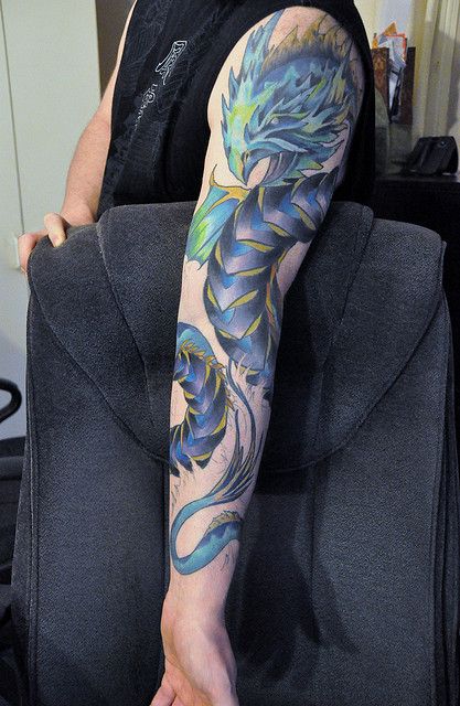 Attractive Colorful Leviathan Tattoo On Man Left Full Sleeve By Christian Masot