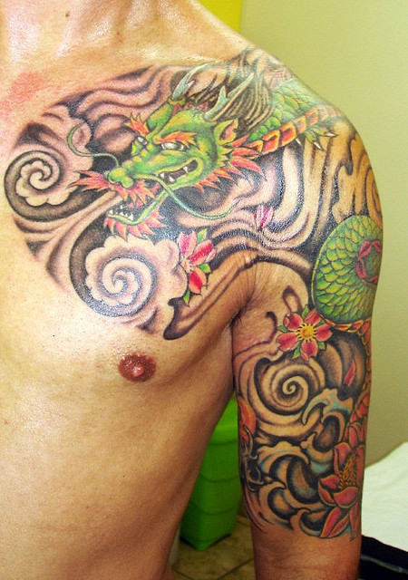Awesome Colorful Traditional Dragon Tattoo On Man Left Shoulder