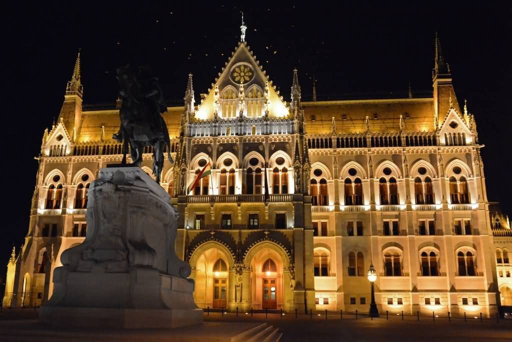 Backside View Of The Hungarian Parliament Building Lit Up At Night