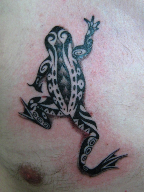 Black And Brown Tribal Frog Tattoo On Chest