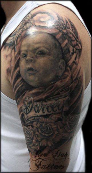 Black And Grey Baby Face With Banner And Roses Tattoo On Left Half Sleeve