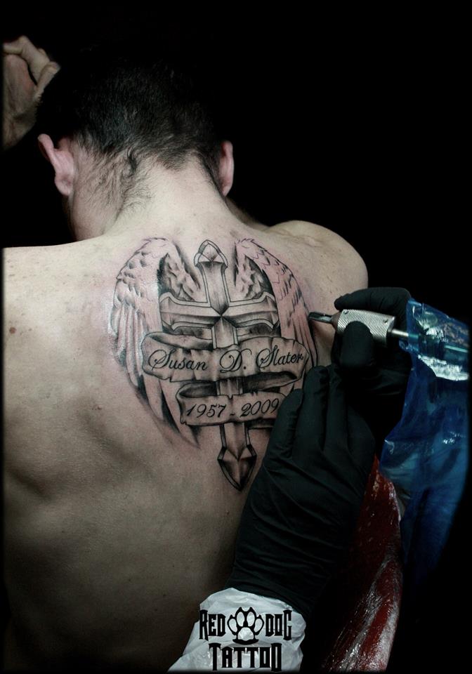 Black And Grey Cross With Wings And Banner Tattoo On Upper Back