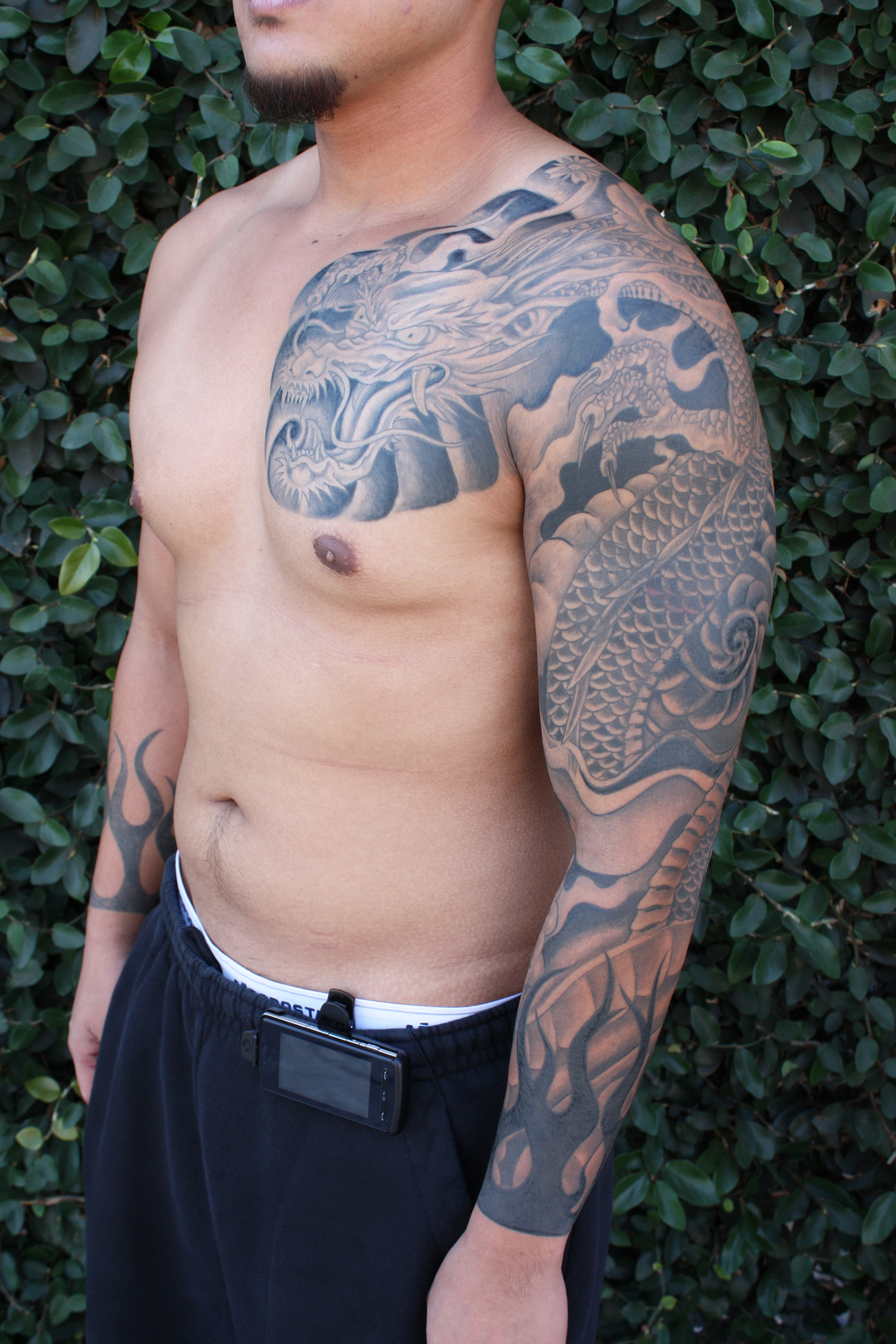 Black And Grey Dragon Tattoo On Man Left Full Sleeve And Front Shoulder