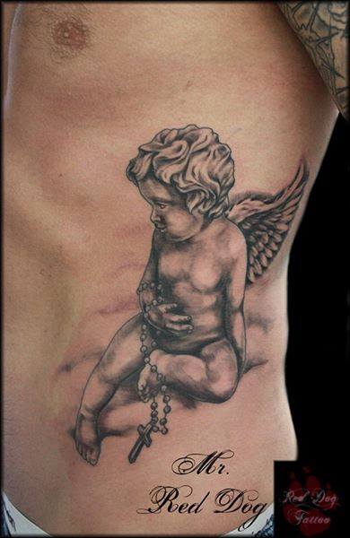 Black Ink Cherub With Rosary Cross Tattoo On Left Side Rib