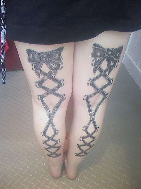 Black Ink Corset With Bow Tattoo On Girl Both Back Leg