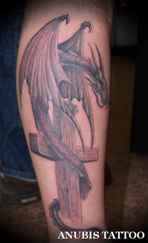 Black Ink Cross With Dragon Tattoo On Leg Calf