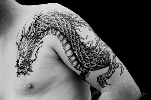 Black Ink Dragon Tattoo On Man Left Front Shoulder