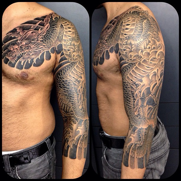 Black Ink Dragon Tattoo On Man Left Half Sleeve And Front Shoulder