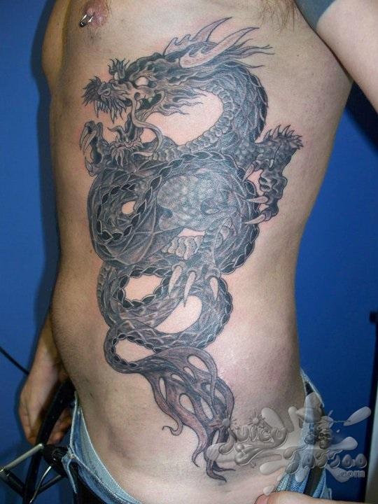 Black Ink Dragon Tattoo On Man Left Side Rib