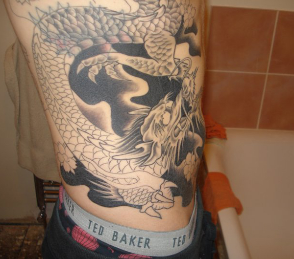 Black Ink Dragon Tattoo On Man Right Side Rib