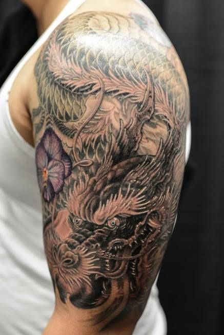 Black Ink Dragon With Flower Tattoo On Left Half Sleeve