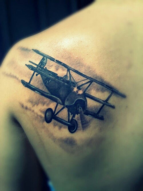 Black Ink Flying Airplane Tattoo On Left Back Shoulder By Angel