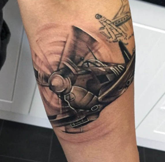 Black Ink Flying Airplane Tattoo On Left Forearm