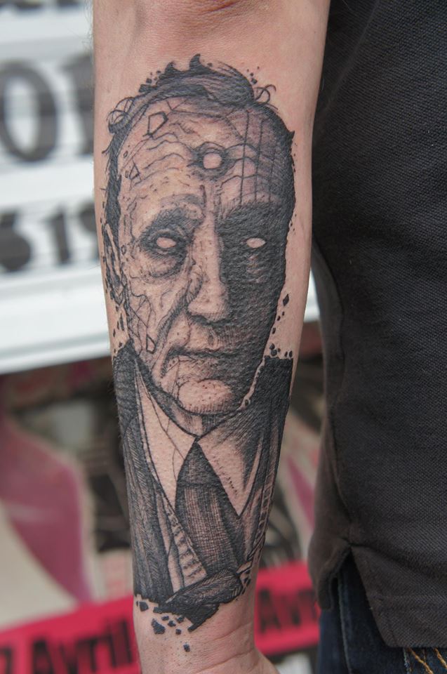 Black Ink Man Face Tattoo On Left Arm by Ergo Nomik