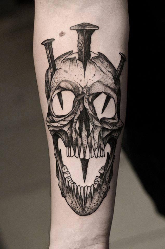 Black Ink Nails In Skull Tattoo On Right Forearm