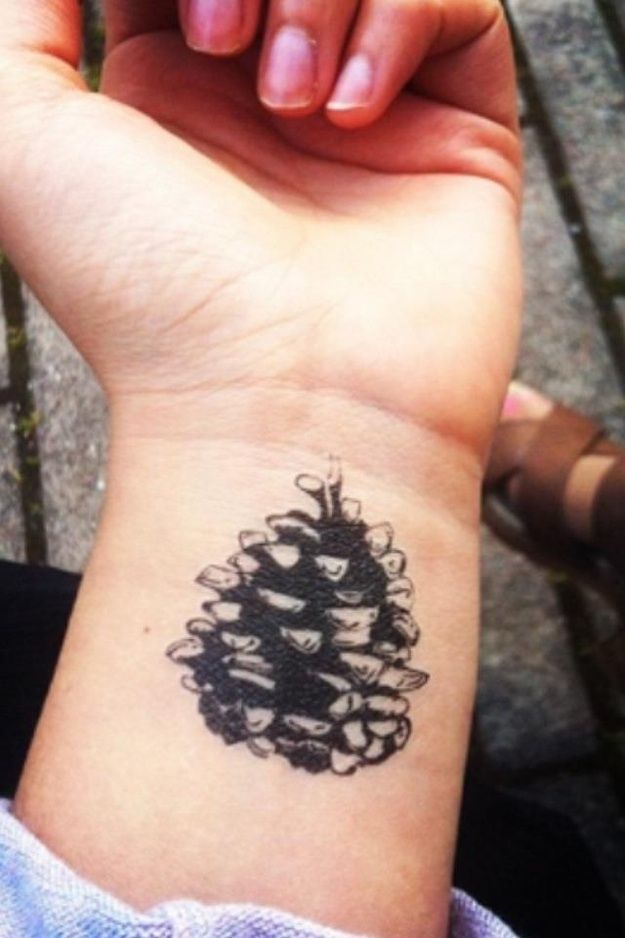 Black Ink Pine Cone Tattoo On Left Wrist