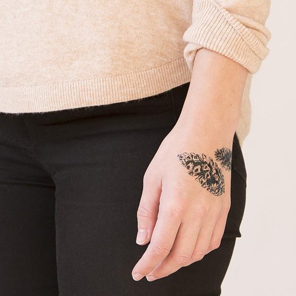 Black Ink Pine Cone Tattoo On Women Left Hand