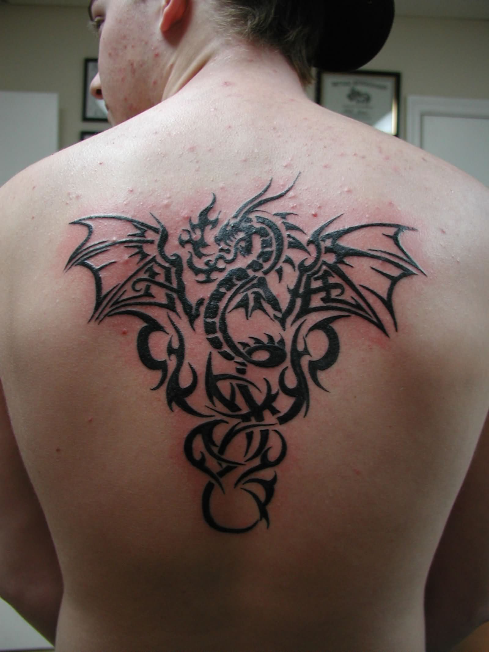 Black Ink Tribal Dragon Tattoo On Upper Back