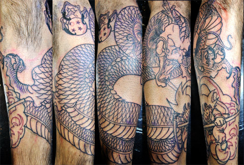 Black Ink Wrap Around Dragon Tattoo On Leg