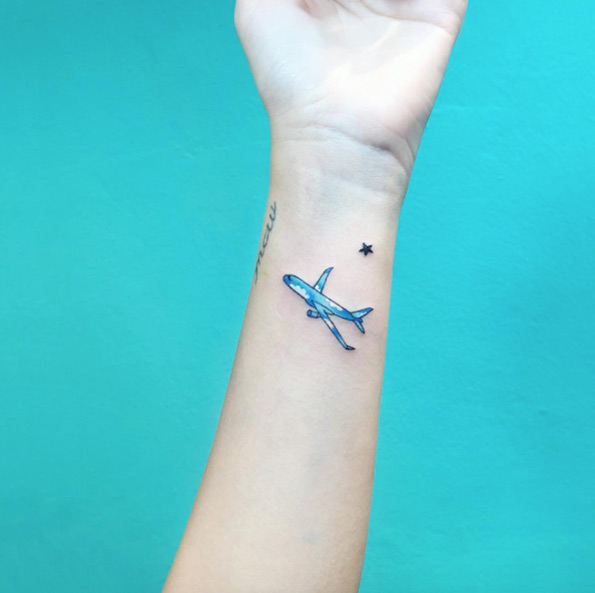 Blue Ink Airplane Tattoo On Left Wrist