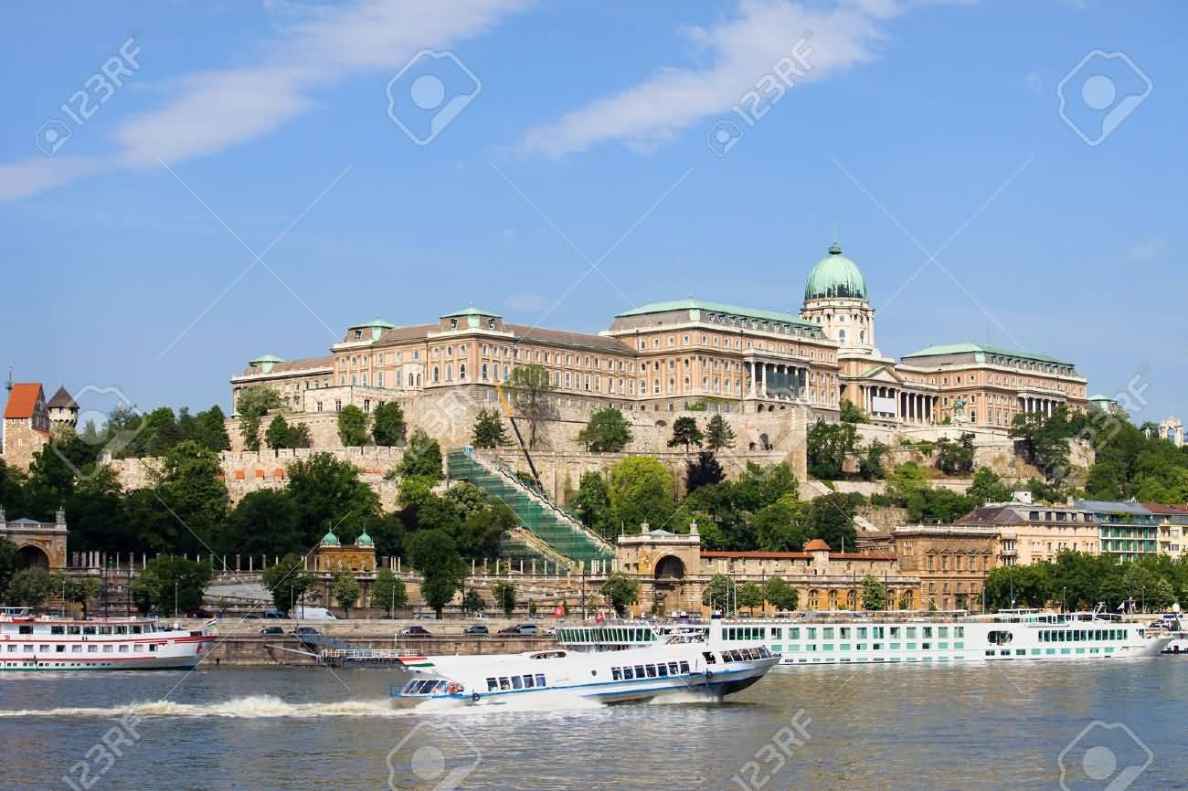 Buda Castle And Passenger Boats On The Danube River In Budapest