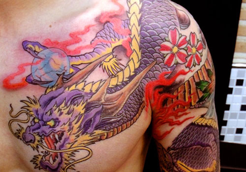Colorful Traditional Dragon Tattoo On Man Left Shoulder And Chest
