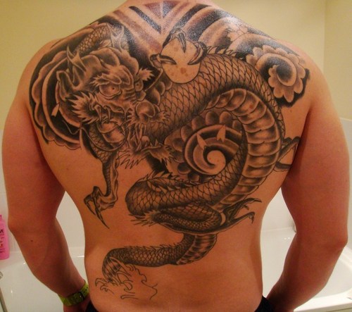 Cool Black Ink Dragon Tattoo On Man Upper Back