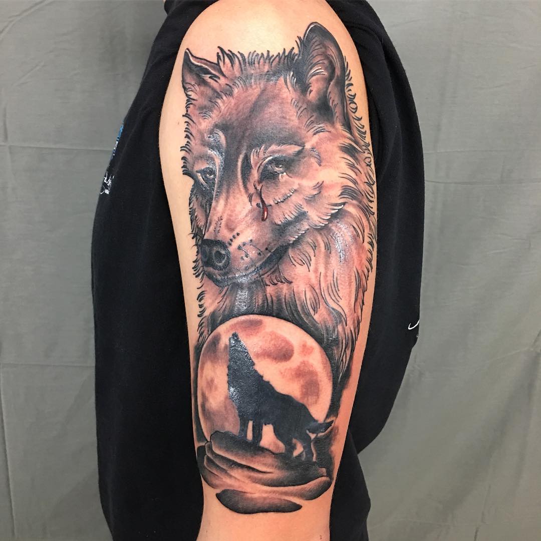 Crying Wolf And Howling Wolf Tattoos On Man Left Sleeve