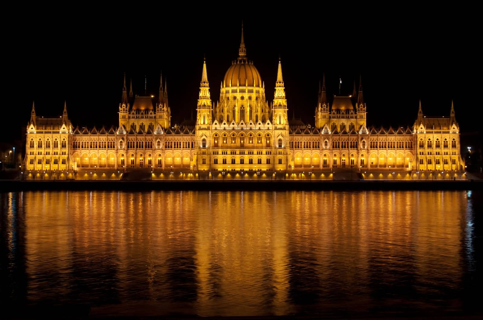 Front View Of Hungarian Parliament Building Across The River At Night