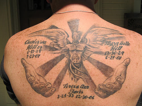 Grey Ink Memorial Tattoo On Upper Back