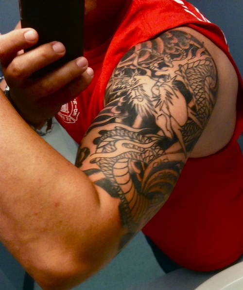 Impressive Black Ink Dragon Tattoo On Man Left Half Sleeve