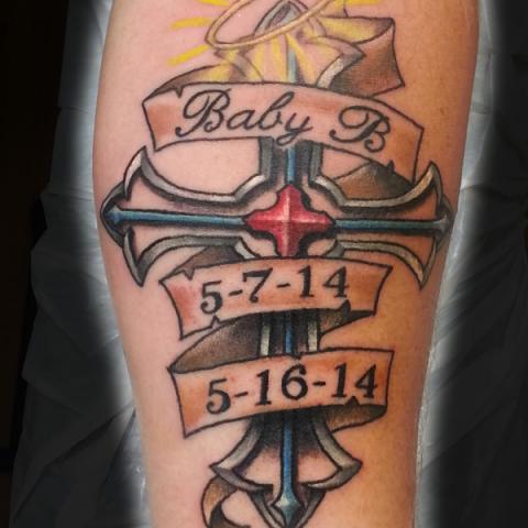 Memorial Banners And Cross Tattoo On Leg