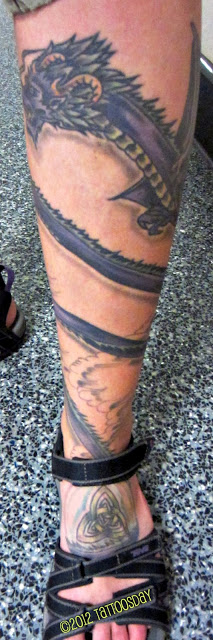 Purple Ink Dragon Wrap Around Tattoo On Left Leg