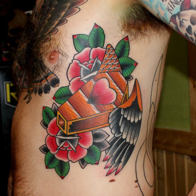 Traditional Coffin With Roses Tattoo On Man Left Side Rib
