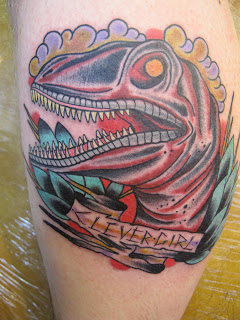 Traditional Dinosaur With Banner Tattoo On Leg Calf