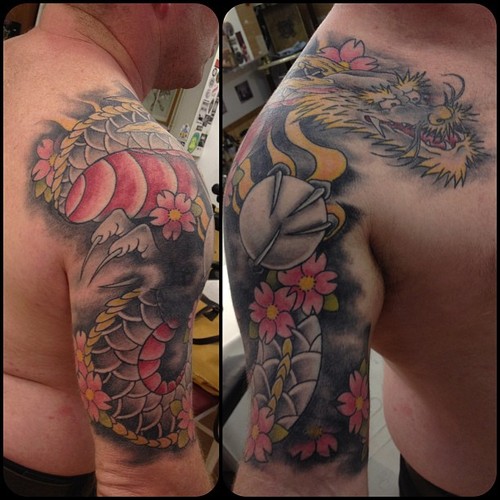 Traditional Dragon With Flowers Tattoo On Man Right Shoulder