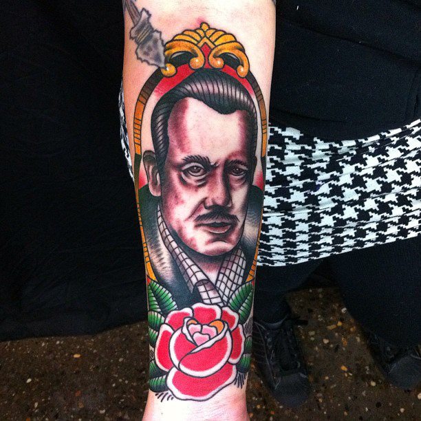 Traditional John Steinbeck In Frame With Rose Tattoo On Forearm By Myke Chambers