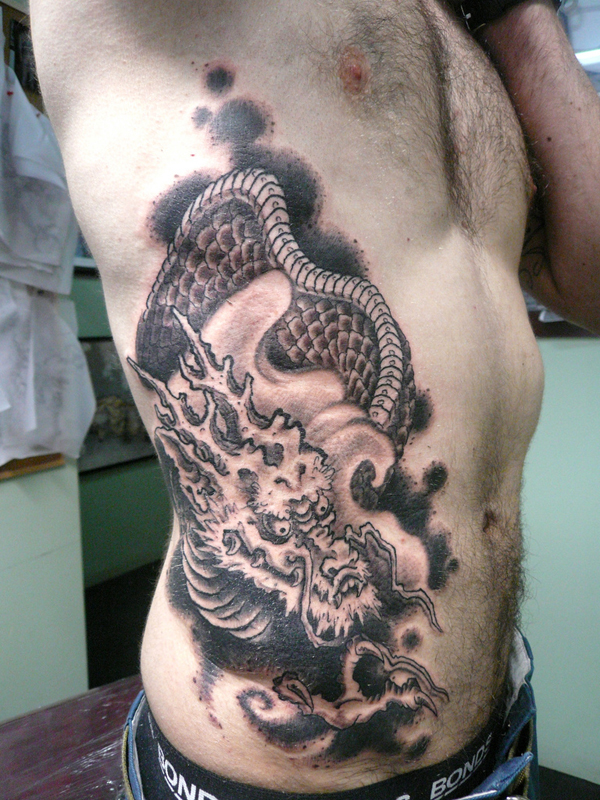 Wonderful Black Ink Dragon Tattoo On Man Right Side Rib